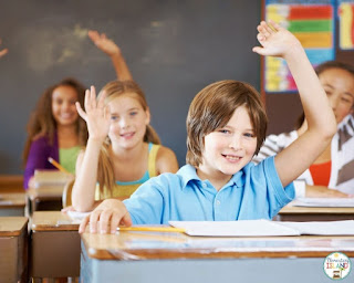 A boy raising his hand to answer a question. Having students raise their hand is an important routine to establish the beginning of the school year.