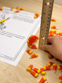 Child measuring stacked candy corn for a fun Halloween STEM activity